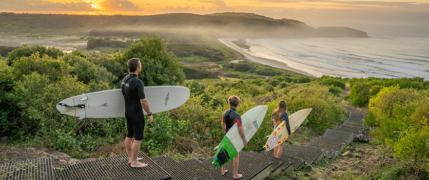 Surfers walking to Killalea beach
