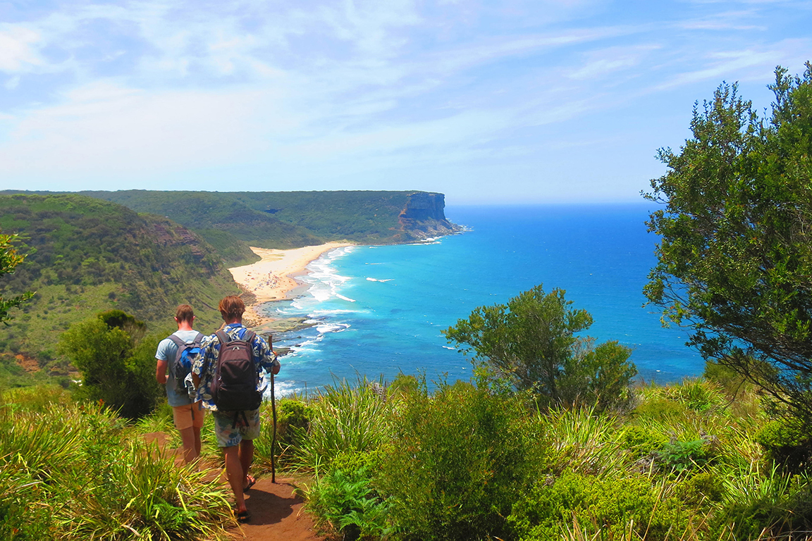 Two men bushwalking on coastal track