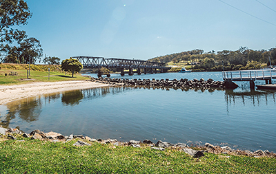 View of parklands and bridge over lake