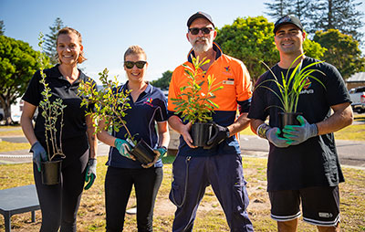 Reflections Holiday Park's Justine Syme and Gordon Elliott plant a native garden with Madi and Ed from Aboriginal education organisation Deadly Ed