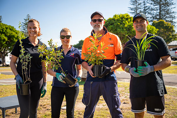 Reflections Holiday Park's Justine Syme and Gordon Elliott plant a native garden with Madi and Ed from Aboriginal education organisation Deadly Ed