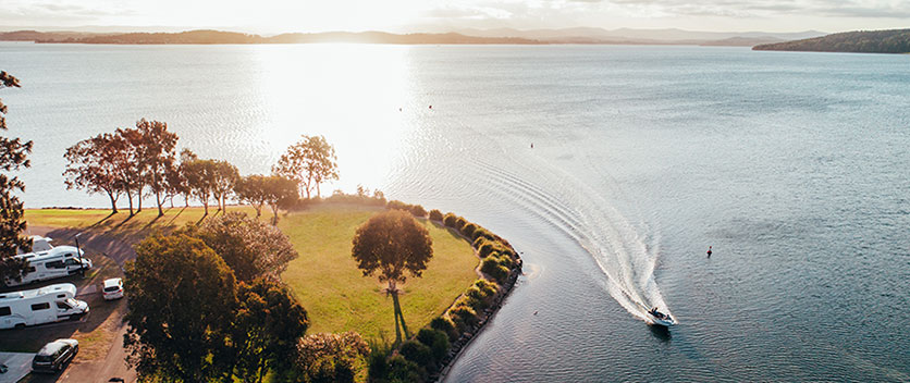 Aerial view of boat on lake with mountains in distance