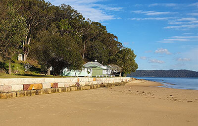 House sitting close to sandstone seawall overlooking lake