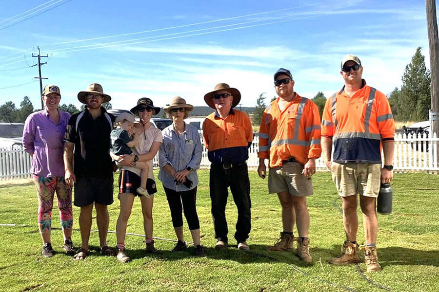 Crown land managers at Bogan Gate Recreation Reserve standing in a row at an award ceremony on a grassy field.