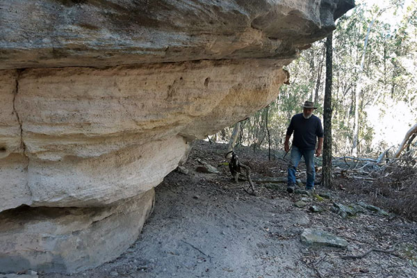 Former ranger and conservation volunteer Peter Swain explores a rock shelter