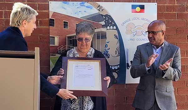 Crown Lands Deputy Secretary Melanie Hawyes presents the land title to
Orange Local Aboriginal Land Council Board member Aunty Mary Parker Crown Lands Deputy Secretary Melanie Hawyes presents the land title to Orange Local Aboriginal Land Council Board member Aunty Mary Parker