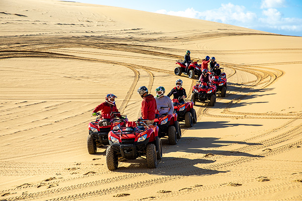 Small group enjoying an Aboriginal cultural tour on quad bikes. Image: Destination NSW